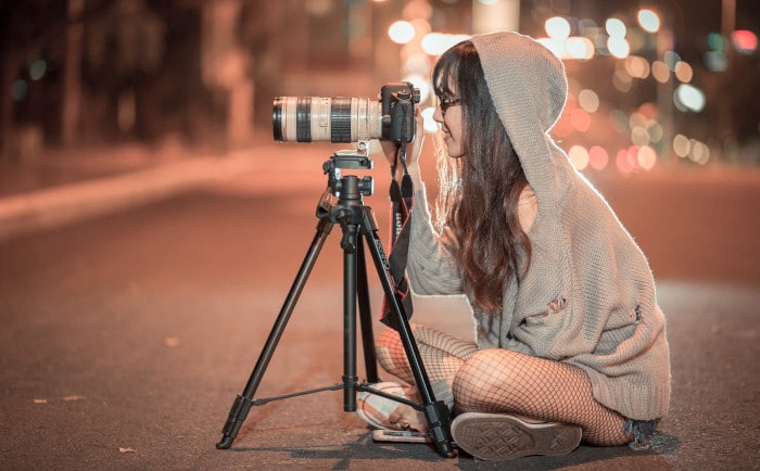 Eine junge Frau fotografiert in der Dämmerung