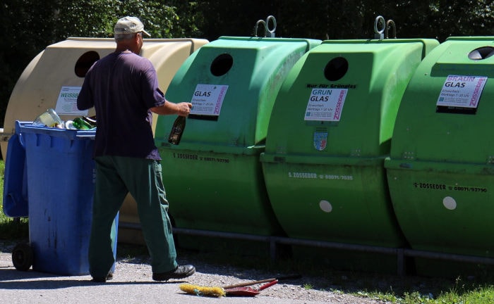 Ein Mann bringt Glasflaschen weg