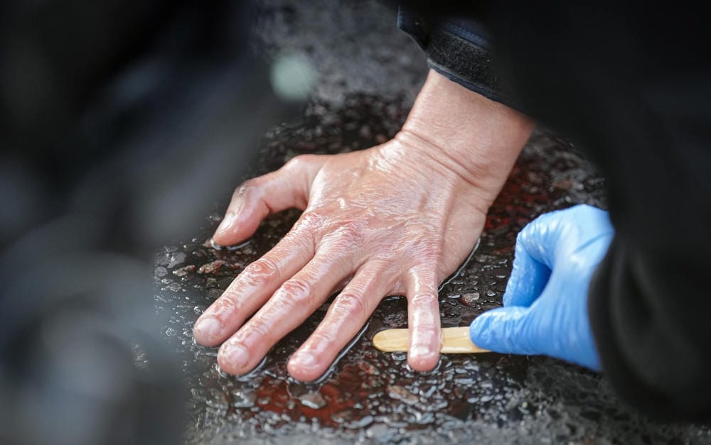 Polizist löst die Hand eines Klimaklebers ab