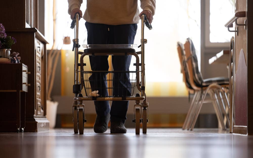 Bewohner im Pflegeheim geht mit Rollator den Gang entlang: Stark gestiegene Zahl der Pflegefälle