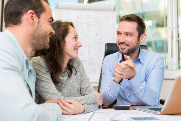 Junger Berater berät Paar zu Immobilien: Bei der Wüstenrot &amp; Württembergischen-Gruppe können sich Azubis als Immobilienkaufmann ausbilden lassen. (Foto: picture alliance / Panther Media | Périg MORISSE)