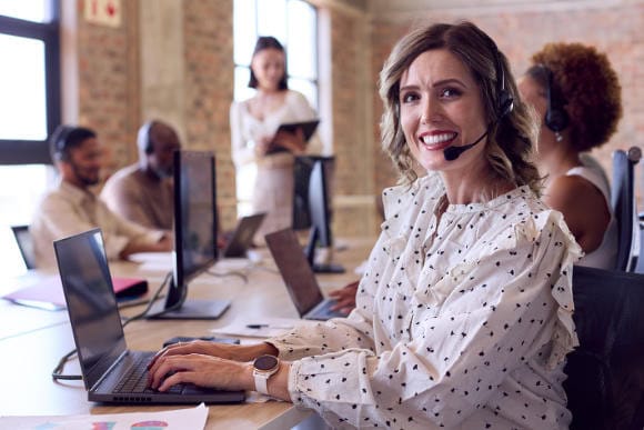 Junge Frau mit Headset berät Kunden am Laptop: Viele Versicherer sind auf der Suche nach Nachwuchsberatern. (Foto: picture alliance / Shotshop | Monkey Business 2)