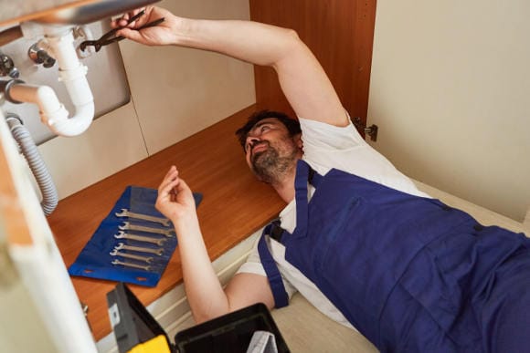 Handwerker, der eine Spüle repariert: In der Steuererklärung für das Jahr 2023 können Angestellte bis zu 20 Prozent der Handwerkerkosten steuerlich geltend machen. (Foto: picture alliance / Zoonar | Robert Kneschke)