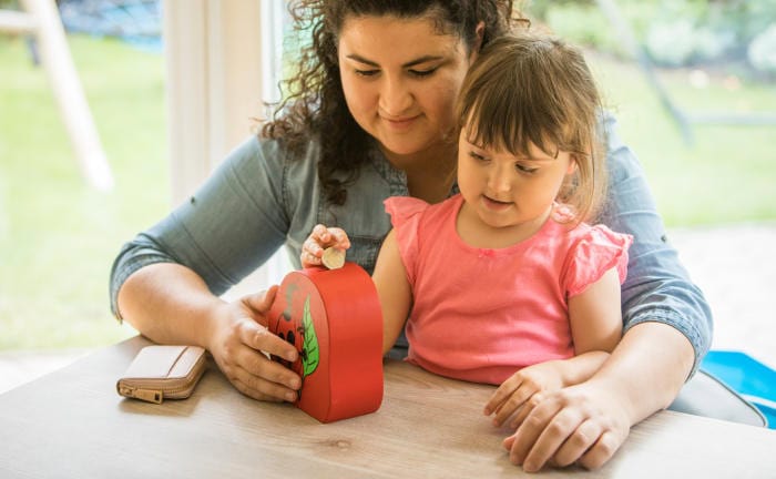 Frau mit Kind, die zusammen ein Sparschwein befallen: Knapp drei Viertel aller Deutschen legt Geld für künftige Ausgaben zurück.