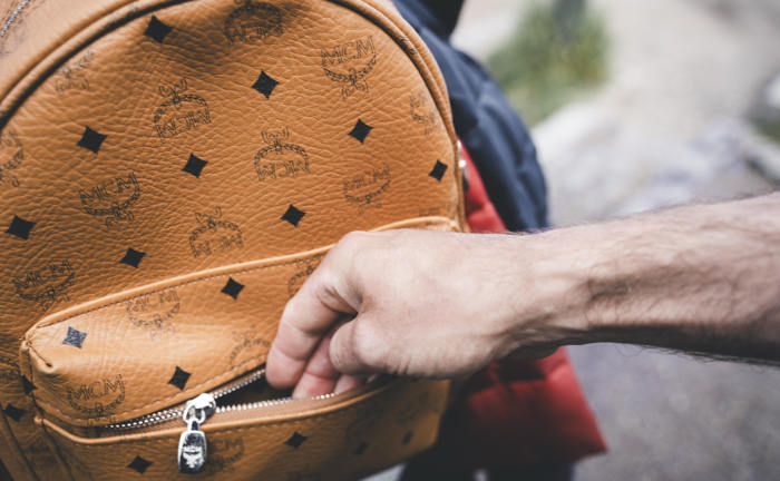 Dieb öffnet Rucksack einer Person: Im Schnitt erbeuten kriminelle Mitarbeiter pro Fall Schäden bis zu 125.000 Euro.