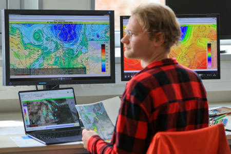 Ein Mann arbeitet an einer Wettervorhersage am Institut für Meteorologie der Universität Leipzig: Wettervorhersagen sind schwer zu treffen. Foto: picture alliance/dpa | Jan Woitas