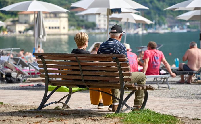 Zwei Rentner sitzen auf einer Bank am Strand: Um ihre gesetzliche Rente aufzubessern, setzen viele auf Fondspolicen mit Garantien.