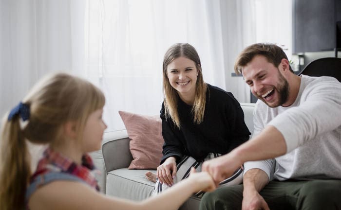 Familie sitzt gemeinsam auf der Couch: Viele Personen nutzen Tarife von Lebensversicherungsgesellschaften für die Altersvorsorge ihrer Familie.