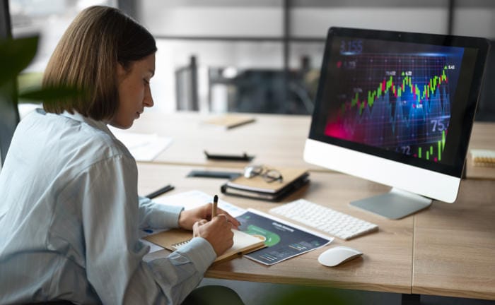 Frau analysiert Börsencharts: Mit der neuen Fondsrente der Barmenia-Gothaer können Kunden am Kapitalmarkt investieren.