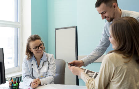 Junges Paar hat einen gemeinsamen Termin mit einer Ärztin: Ausgaben für die PKV können Steuerpflichtige für drei Jahre im Voraus zahlen. Foto: Freepik