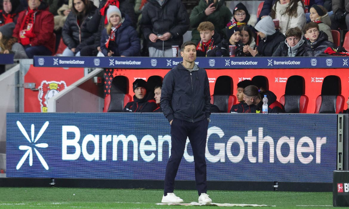 Xabi Alonso, Trainer von Bayer Leverkusen, steht im Fußballstadion vor einer Werbung der Barmenia-Gothaer: Der Versicherungsverein hat für sein Fusionsjahr 2024 die Prognose für die Beitragseinnahmen veröffentlicht.