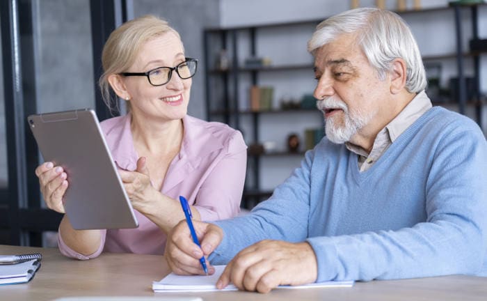 Vermittlerin erklärt Kunden einen Vertrag: Einfirmenvermittler sind der erfolgreichste Vertriebskanal für Lebensversicherungen.