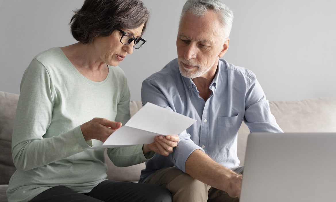 Frau und Mann kontrollieren Arztrechnung: Beitragsrückerstattungen können sich für PKV-Versicherte auszahlen.