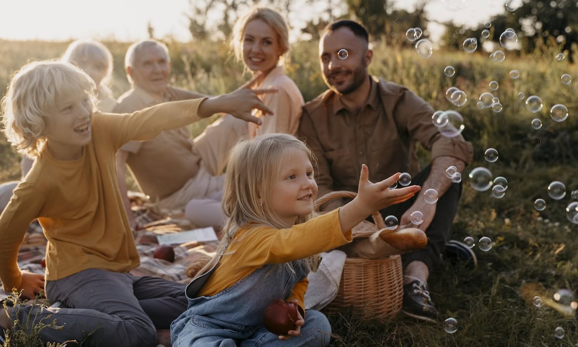 Eine Familie picknickt: Risikolebensversicherungen sichern Hinterbliebene ab.