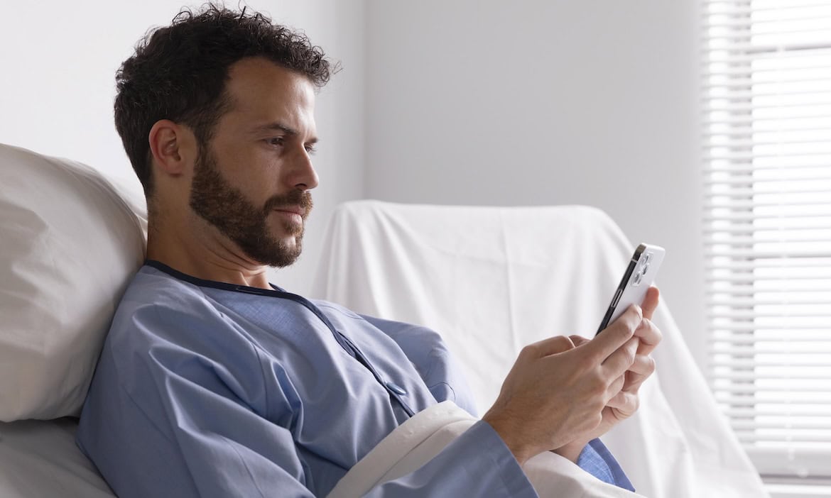 Patient im Krankenhaus checkt sein Smartphone: Ab 29. April können alle GKV-Versicherten die elektronische Patientenakte nutzen.