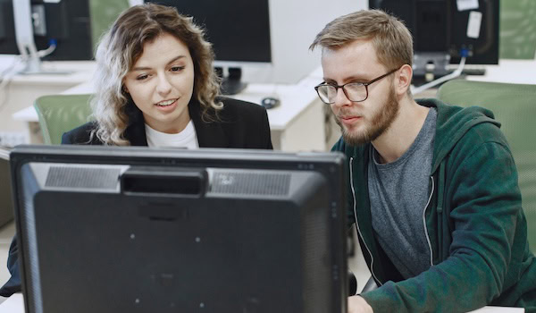 Zwei IT-Spezialisten arbeiten an einem Rechner Foto: Prostoleeh / Freepik