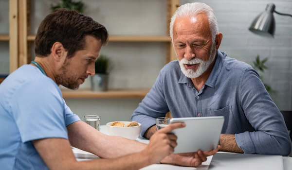Pflegefachkraft spricht mit Patienten Foto: Drazen Zigic