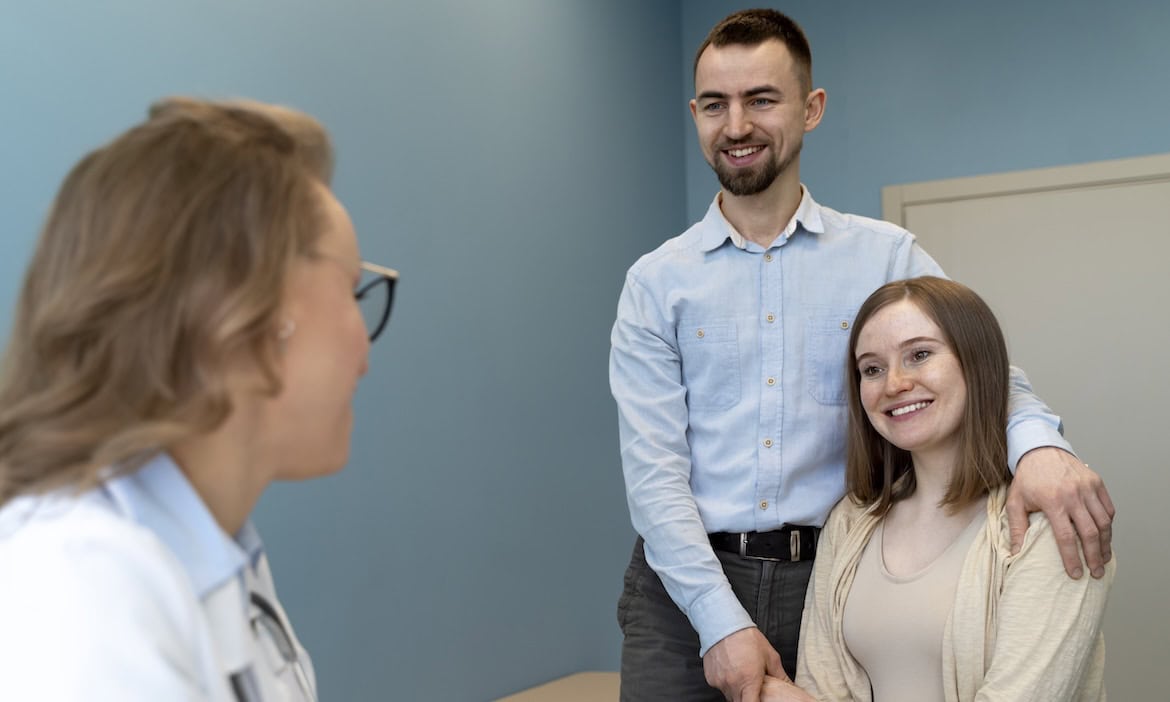 Junges Ehepaar spricht mit Ärztin: Die AOK-Gemeinschaft hat die meisten jungen GKV-Versicherten in Deutschland.