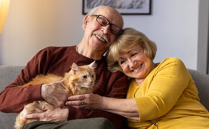 Ein glückliches Ehepaar mit Katze – steuerfreie Fondspolicen bieten Absicherung mit geringer Steuerlast.