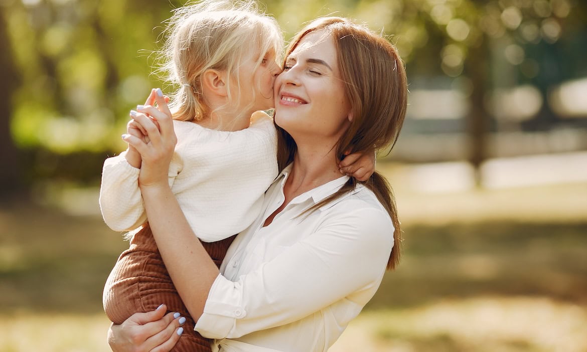 Mutter spielt mit Kind im Park: Die Bundesregierung plant, die Mütterrente ab 2028 auszubauen.