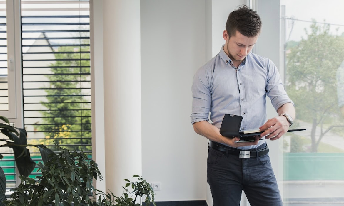 Jungmakler schreibt eine Notiz auf sein Tablet: Jungmakler wünschen sich eine bessere digitale Prozesse von Versicherern.