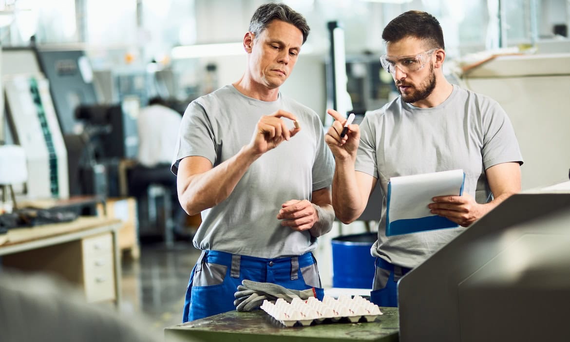 Zwei Industriearbeiter diskutieren über Produkt: Metzler will mit dem Kauf der Nürnberger Pensionsfonds Mittelständlern mehr bAV-Angebote anbieten.