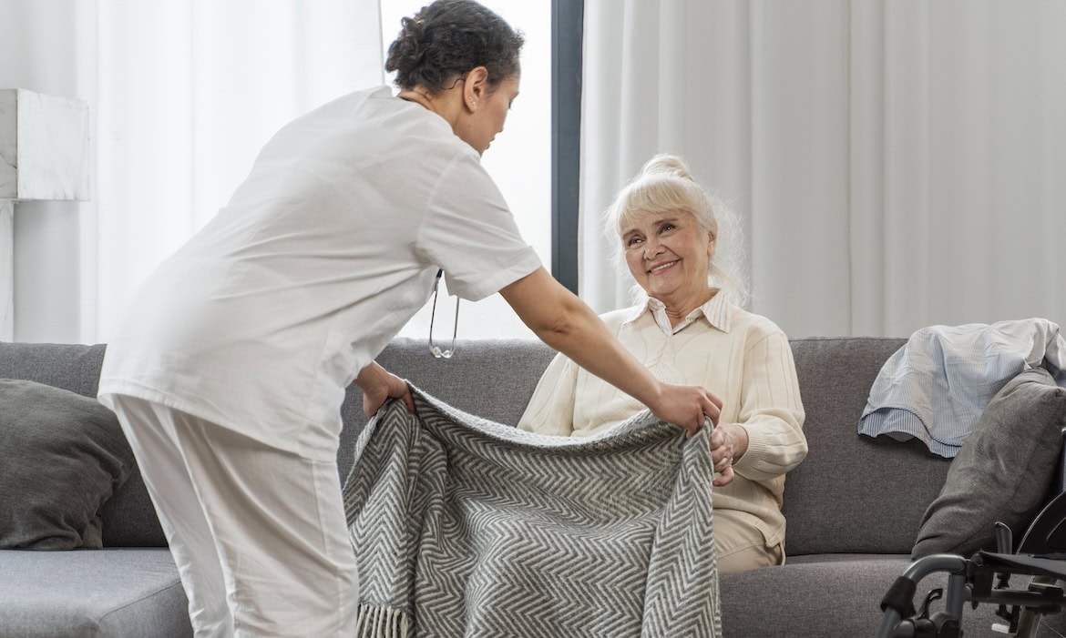 Pflegerin deckt ältere Frau zu: Der Eigenanteil für das Pflegeheim steigt laut Angaben des Vdek erneut.