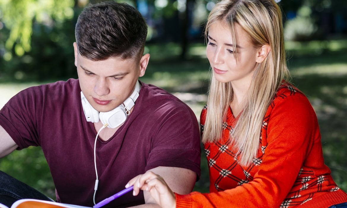 Frau erklärt Mann einen Fachbegriff: Versicherungsdeutsch, also die Sprache in der Versicherungsbranche, ist für viele Versicherungskunden mitunter schwierig zu verstehen.