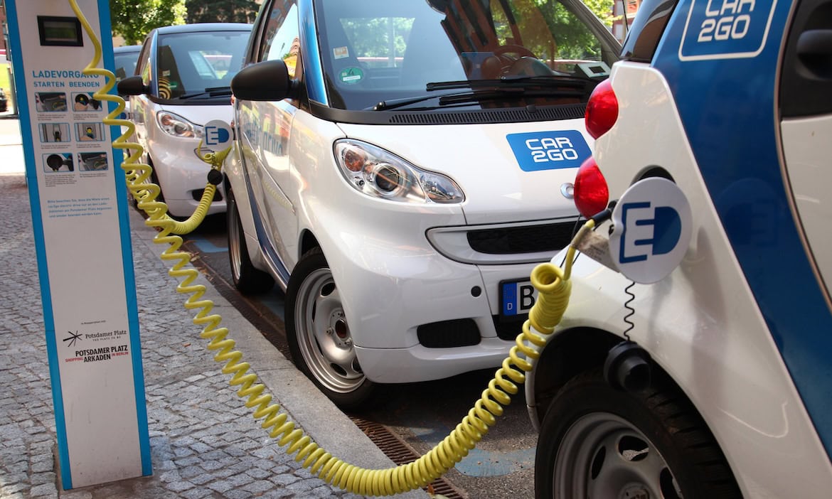 Elektroautos an einer Zapfsäule: Großunternehmen benötigen 2025 neben klassischen Industrieversicherungen neue Deckungskonzepte für E-Autos.