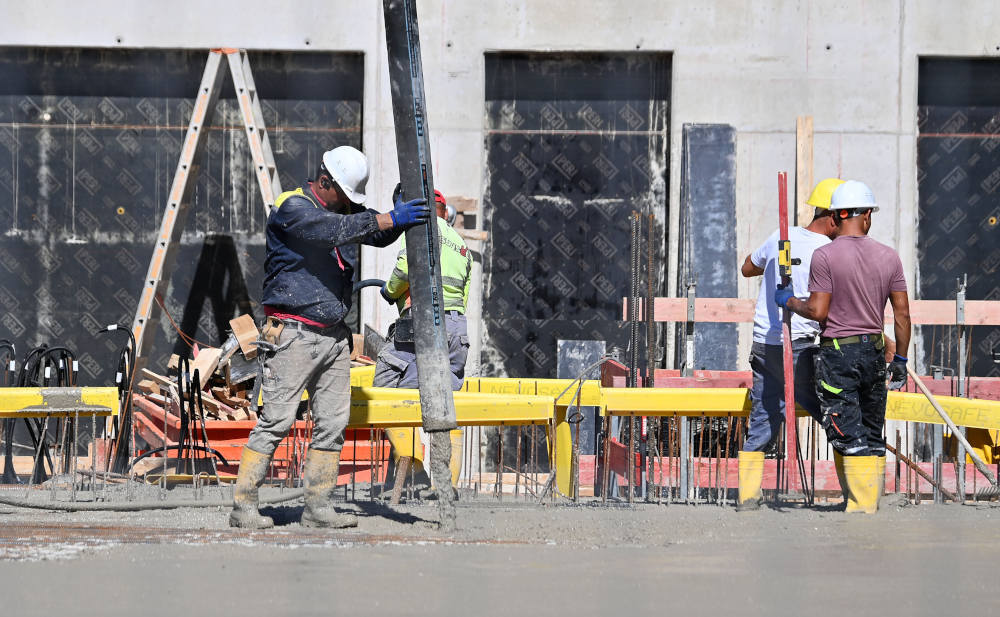 Arbeiter mit Betonpumpe auf Großbaustelle in München: Steigende Bau-, Montage- und Materialpreise