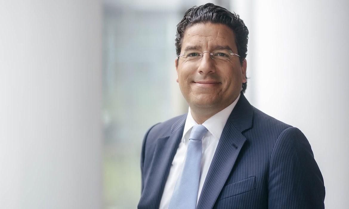 Erfahrener Geschäftsmann im Anzug vor hellem Bürohintergrund, Geschäftsmann, Professional.