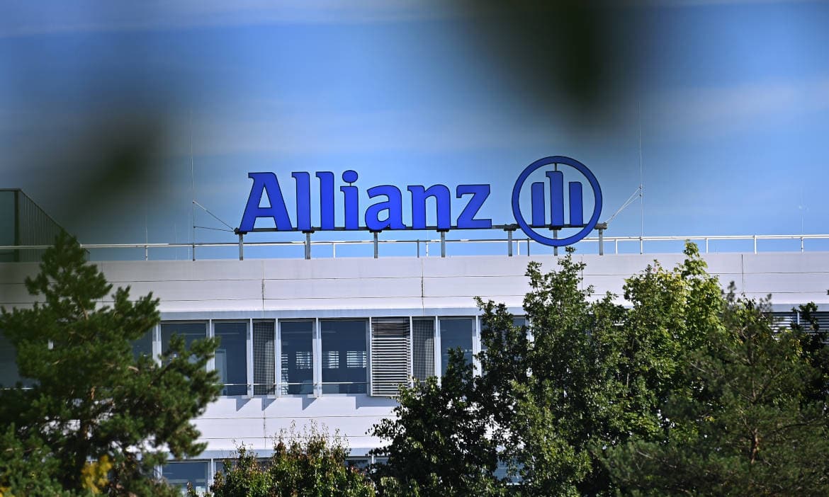 Moderne Allianz Zentrale mit Firmenlogo, umgeben von Bäumen.