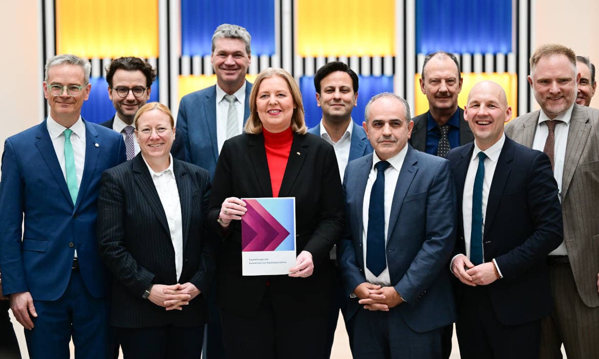 Bärbel Bas (SPD), Bundesministerin für Arbeit und Soziales, mit dem Bericht der Sozialstaatskommission und den Kommissionsmitgliedern im Arbeitsministerium