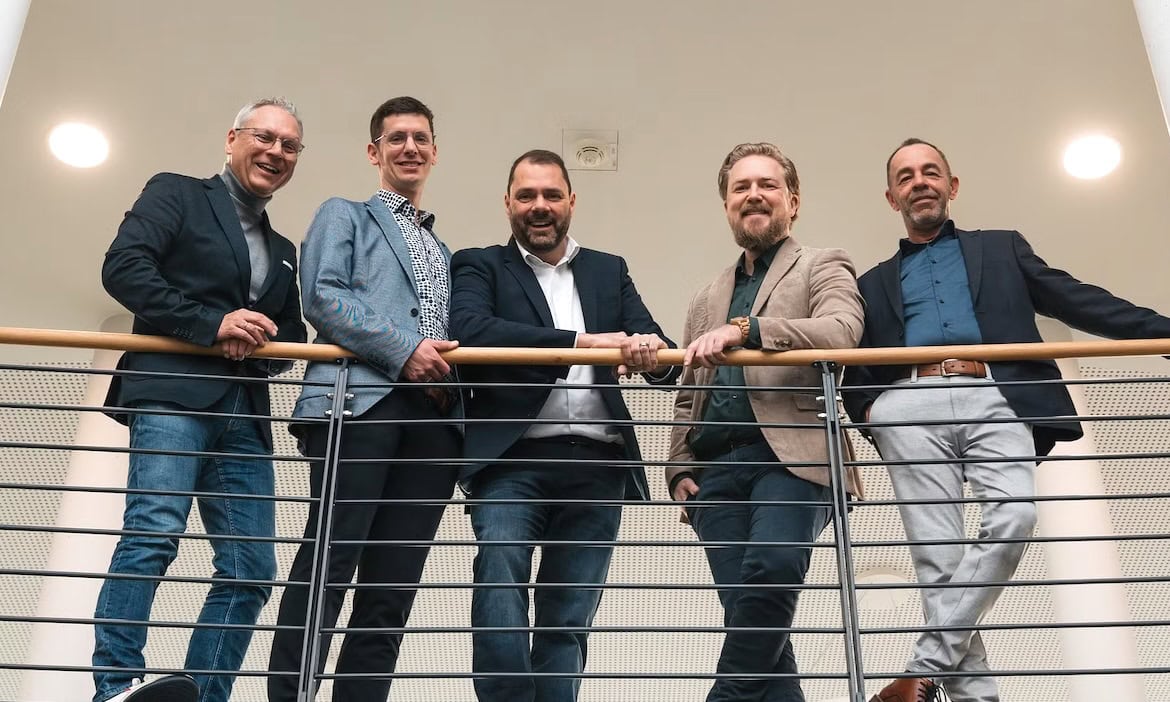 Erfolgreiche Teammitglieder auf einer Bürogalerie, moderne Geschäftskultur, professionelle Atmosphäre.