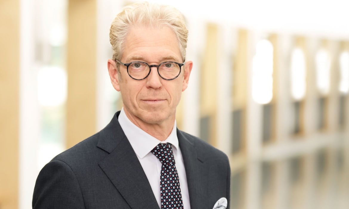 Professioneller Versicherungsberater in Anzug und Brille im Büro.