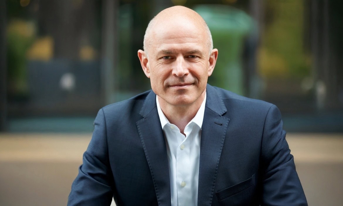 Mann in Businesskleidung vor Bürogebäude, Fokus auf Vergütungsabrechnung.