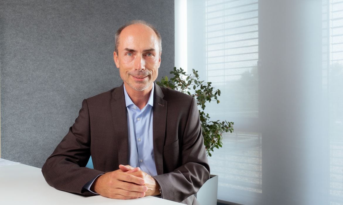 Bernd Schlemann sitzt im modernen Büro, bereit für ein Meeting.