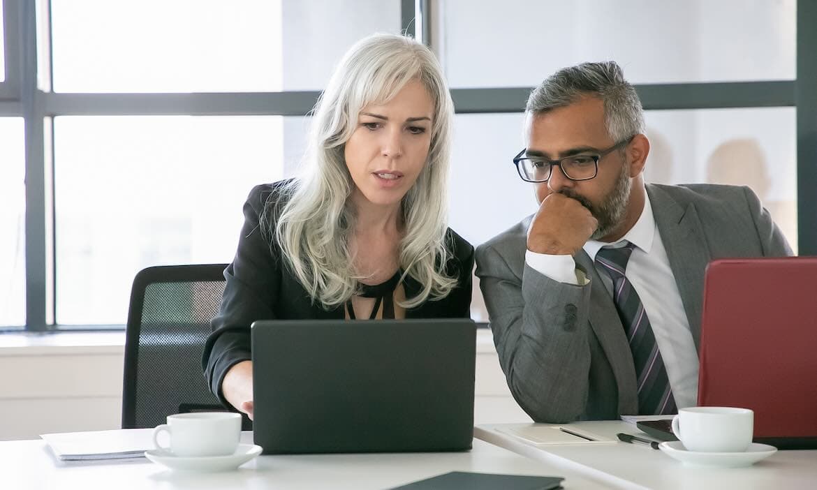 Zwei Geschäftsleute diskutieren Versicherungsfragen im Büro.